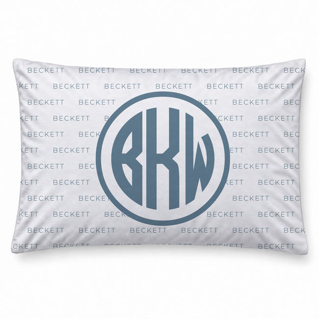 A personalized pillowcase featuring a monogrammed circular design with the letters 'BKW' in a slate blue-gray color. The background of the pillow is white with a repeating light blue 'BECKETT' brand watermark pattern.