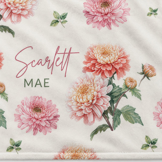 Closeup of a personalized lightweight fleece blanket with peach and pink chrysanthemums and Scarlett Mae lettering.