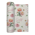 Ivory swaddle blanket with peach and pink chrysanthemums, green foliage, and the name Scarlett Mae in rose and green lettering.