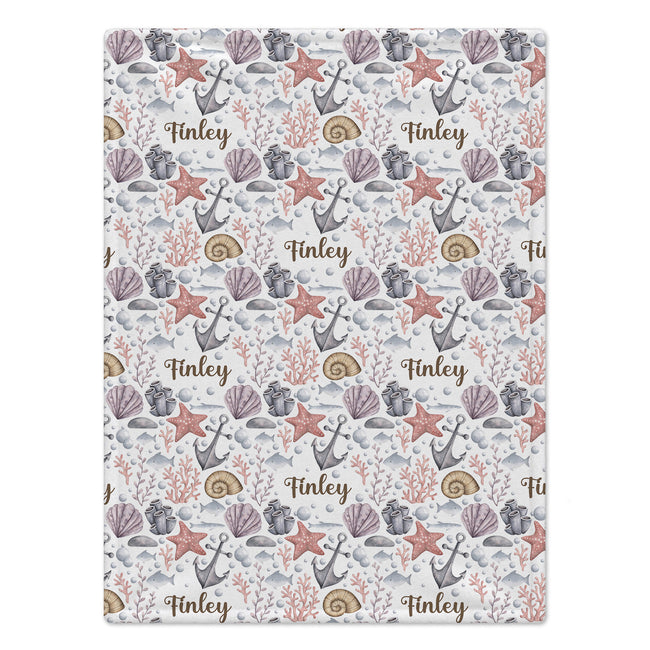 A rectangular fabric or paper product featuring a nautical pattern with anchors, starfish, seashells, coral, and the name 'Finley' repeated in brown script on a light background.
