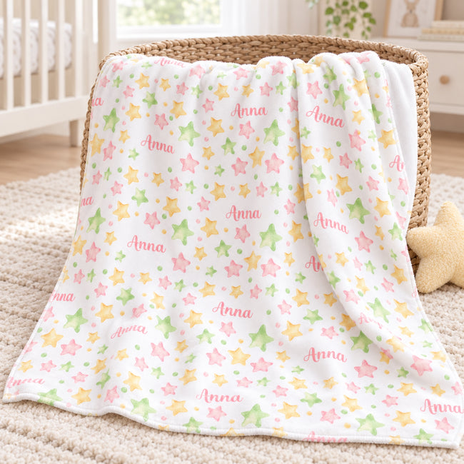 Personalized Pastel Star Baby Blanket. Watercolor stars in soft pink, yellow, and green surround a custom name on a white background.