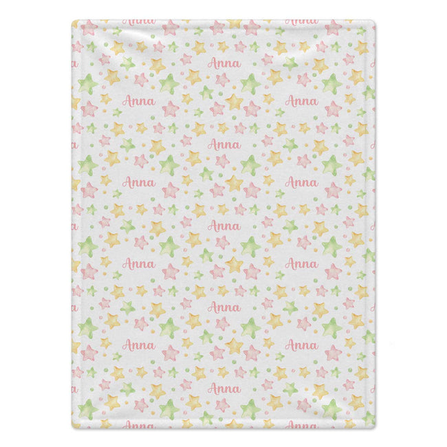 A personalized baby blanket featuring a repeating pattern of pastel pink, yellow, and green stars, dots, and the name 'Anna' printed in script, shown flat against a white background.