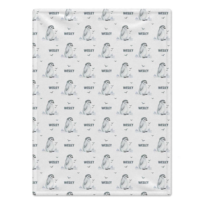 Personalized Penguin Baby Blanket. Sweet baby penguins, icy landscape accents, and little flying birds surround a custom name on a white background.