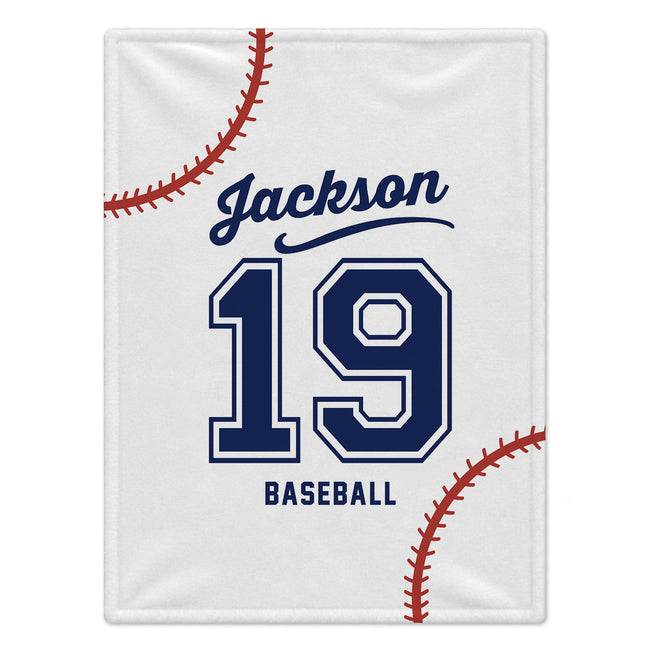 A white baseball-themed blanket featuring navy blue text reading 'Jackson 19 BASEBALL' and red baseball stitching graphics on a white background.
