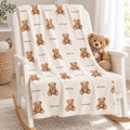 Personalized teddy bear blanket with the name Rowan, draped over a white rocking chair beside a plush teddy bear.