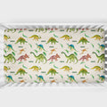 A crib mattress fitted sheet with a colorful dinosaur pattern on a cream background, shown inside a white wooden crib.