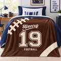 Personalized Henry number 19 football blanket draped over navy bedding in a football-themed bedroom.