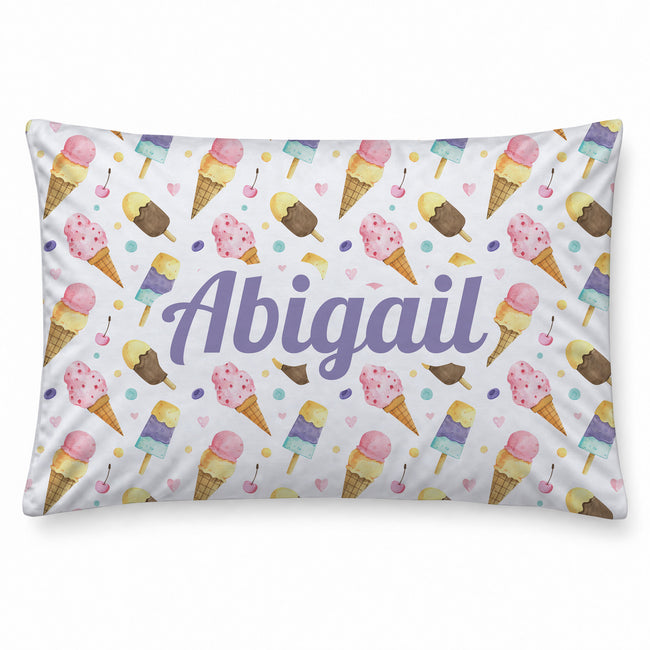 A pillow with a white background covered in a pastel ice cream cone pattern, featuring the personalized name 'Abigail' in large purple script across the center.