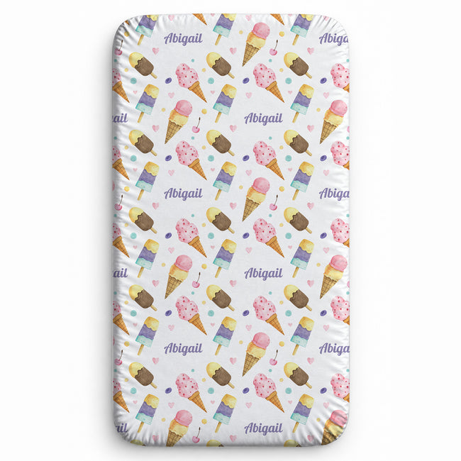 A personalized twin fitted sheet with a white background and an all-over repeating pattern of colorful ice cream cones, pink hearts, and the name 'Abigail' in purple script.