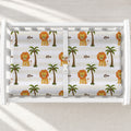 Little Lion changing pad cover with golden lions, green palms, cream and white stripes, and the name Leo, shown on a white changing table.