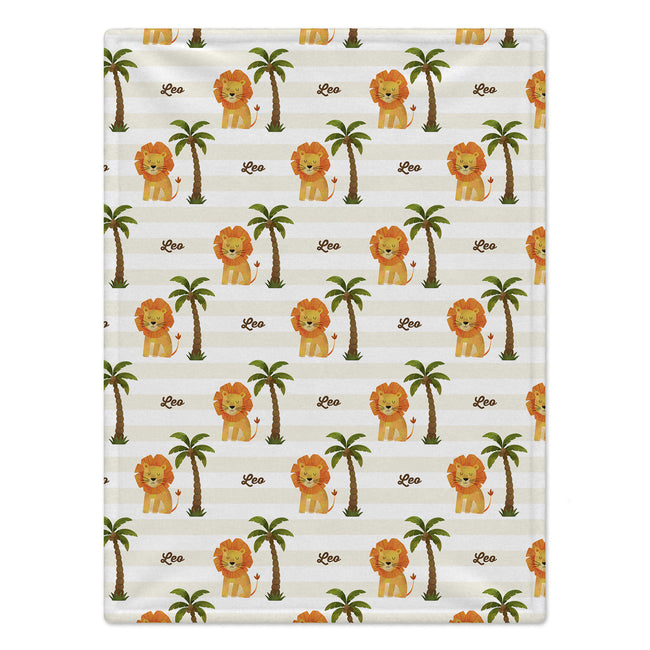 Full view of Little Lion baby blanket with repeating golden lions, green palm trees, and Leo in brown script over cream and white stripes.