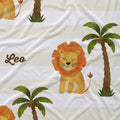 Close-up of Little Lion fabric showing a golden lion with an orange mane, a green palm tree, and Leo in brown script on cream and white stripes.