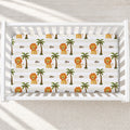 Little Lion personalized crib sheet with golden lions, green palms, cream and white stripes, and the name Leo in a white crib.