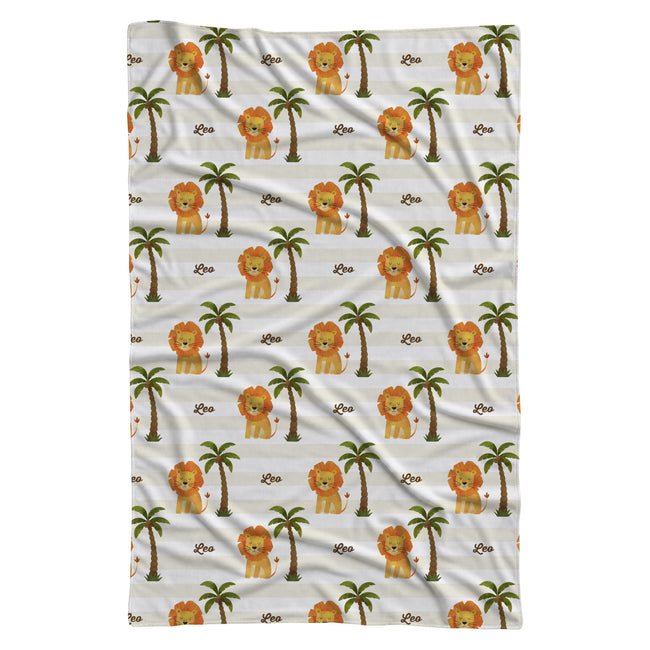 Full view of Little Lion personalized swaddle blanket with golden lions, palm trees, and Leo in brown script on cream and white stripes.