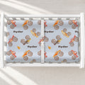 Monster Trucks changing pad cover personalized with Ryder, featuring colorful watercolor trucks on pale blue in a white changing table.