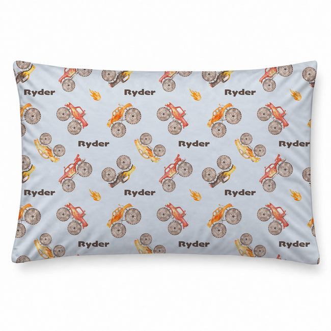 Monster Trucks pillowcase personalized with brown Ryder lettering, featuring colorful watercolor trucks and orange flames on a pale blue background.