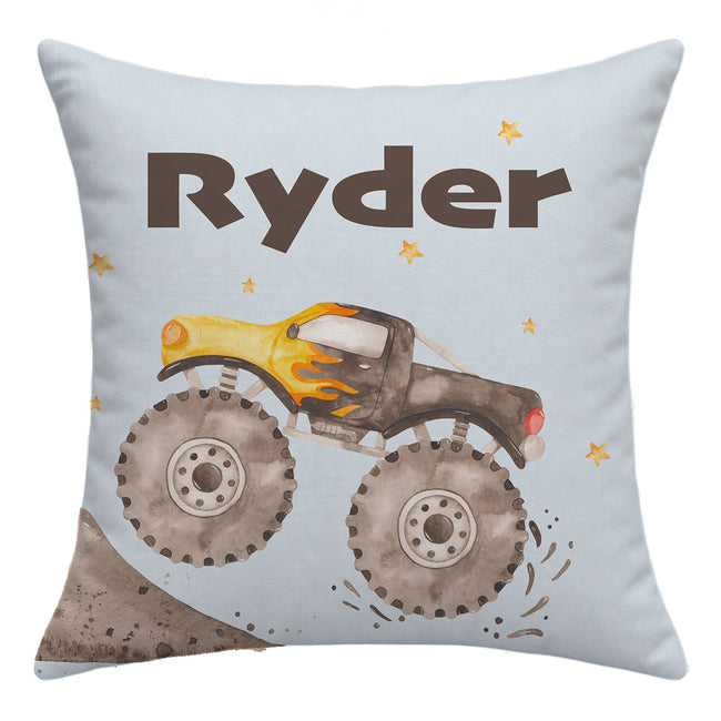 Front of the Monster Trucks throw pillow with large brown Ryder lettering above a charcoal and yellow watercolor truck on pale blue.
