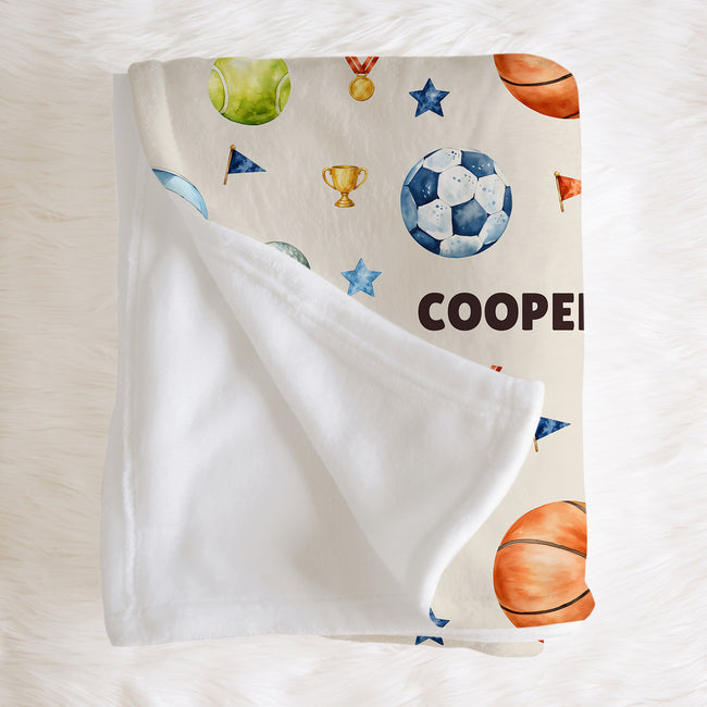 Personalized sports blanket featuring basketball, baseball, soccer, golf, volleyball, football, tennis and with name Cooper on it