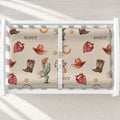 Wild West changing pad cover personalized with Scout, featuring cream cowboy print on a contoured pad in a white changing table.