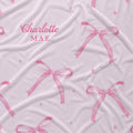 Personalized blush pink fabric with watercolor bows, tiny sparkles, and the name Charlotte Mae.