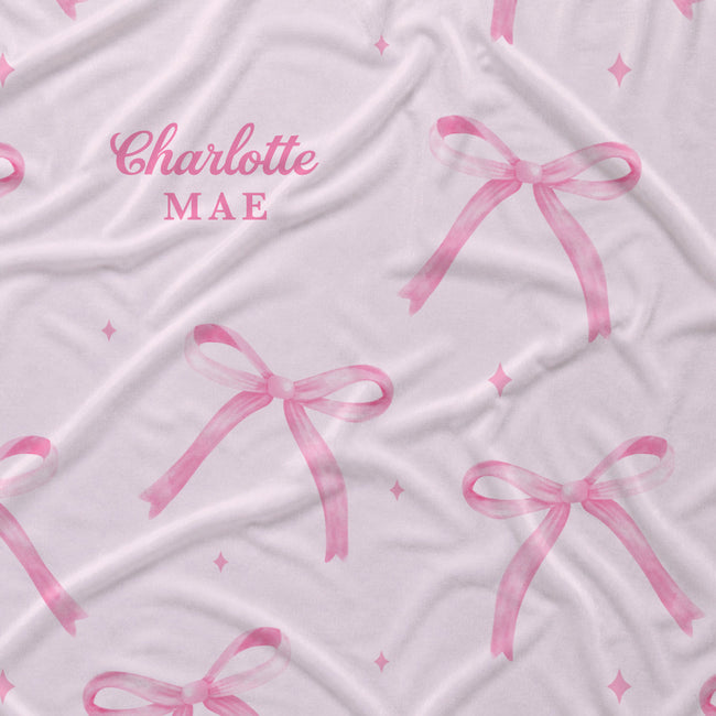 Personalized blush pink fabric with watercolor bows, tiny sparkles, and the name Charlotte Mae.