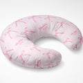 Blush pink nursing pillow cover with watercolor bows, tiny sparkles, and the name Charlotte Mae repeated in pink lettering.