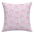 Back of a blush pink throw pillow featuring a repeating watercolor bow pattern and tiny pink sparkles without lettering.