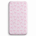 Blush pink twin fitted sheet with watercolor bows, tiny sparkles, and the name Charlotte Mae repeated in pink script and uppercase lettering.