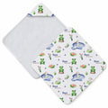 A white baby hooded towel with a whimsical pond and frog pattern, featuring green frogs, blue water, pink lotus flowers, and the personalized name 'Inox William' printed repeatedly. The reverse side is solid white.