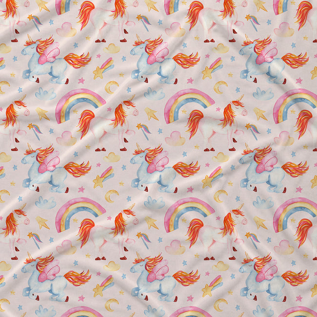 A close-up of a fabric surface with a repeating whimsical print featuring unicorns, rainbows, stars, hearts, and crescent moons on a light warm background.