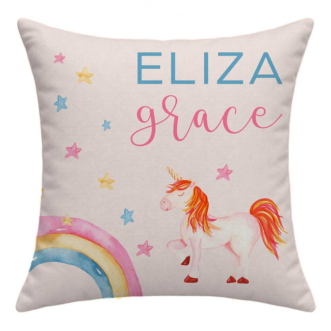 Personalized square throw pillow featuring a watercolor-style unicorn, rainbow, and stars with the names 'ELIZA' and 'grace' printed on a light beige fabric background.