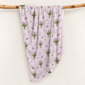 Mauve-pink swaddle blanket with lavender aster bouquets, golden centers, green leaves, and the name Evelyn Claire.