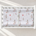 A white changing table with a personalized changing pad cover featuring white background and a winter snowman pattern.