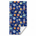 Space Explorers beach towel personalized with Scout, featuring watercolor planets and rockets on navy, with one corner folded to show the white reverse.