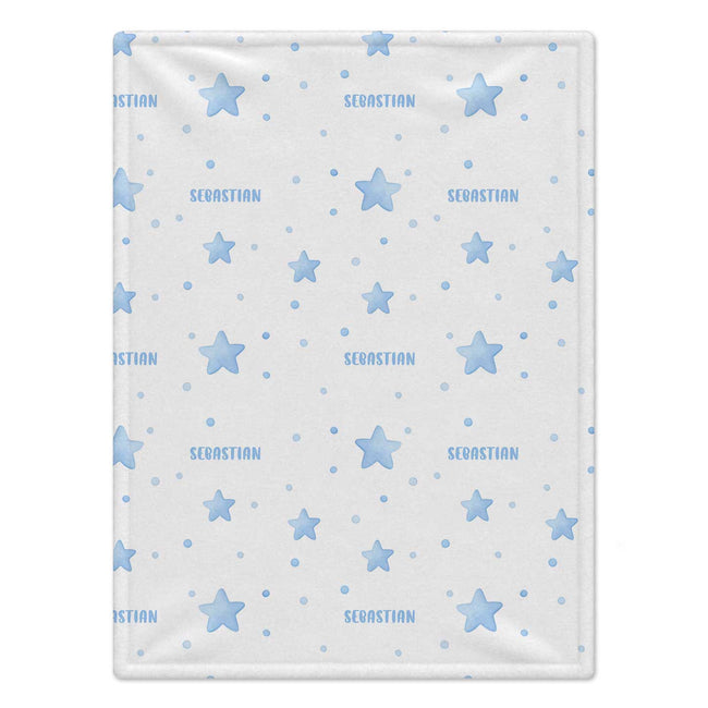 A personalized baby blanket featuring a light blue star and polka dot pattern on a white background, with the name 'SEBASTIAN' repeated in blue text.
