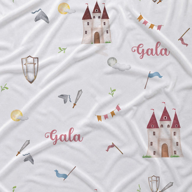 White fabric with a repeating pattern of watercolor-style castles, flags, swords, shields, clouds, and the word 'Gala' in pink script.