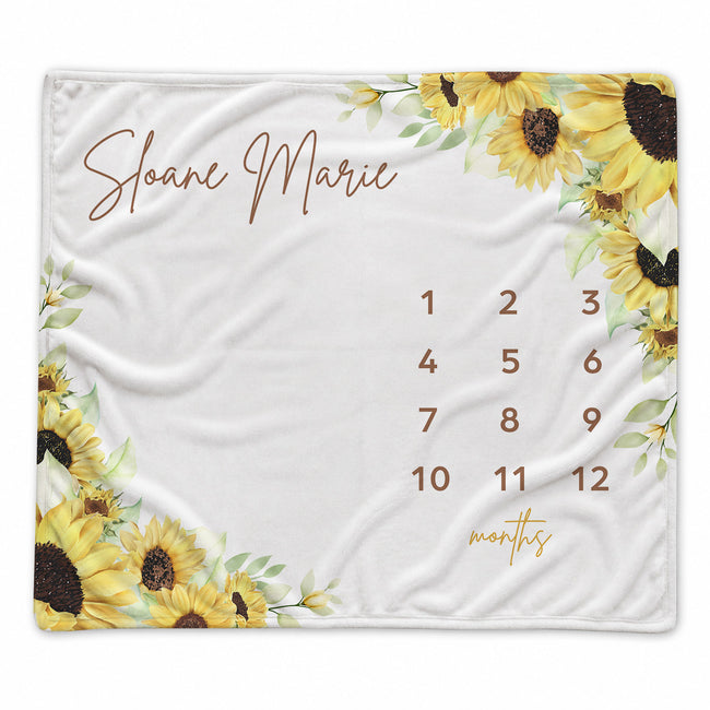 Personalized Sunshine and Sunflowers baby milestone blanket with yellow sunflowers, greenery, custom name, and months 1–12