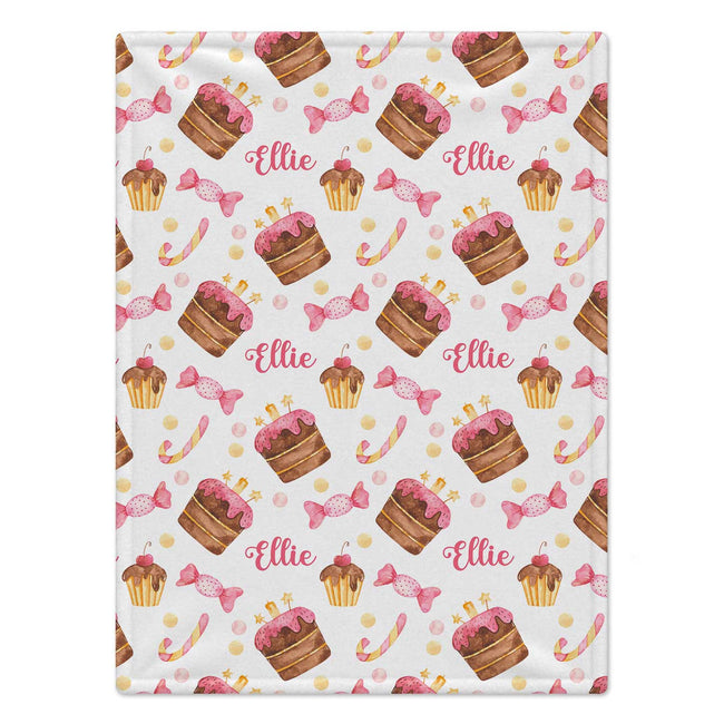 A personalized blanket featuring a repeating pattern of pink frosted cupcakes, pink lollipops, and the name 'Ellie' in pink script on a white background.