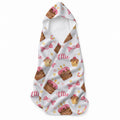 White hooded towel with pink-frosted cakes, cupcakes, wrapped sweets, candy canes, pastel dots, and the name Ellie in pink script.