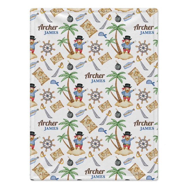 A personalized blanket featuring a pirate-themed pattern with palm trees, treasure maps, ship's wheels, and the custom text 'Archer JAMES' printed repeatedly on a white background.