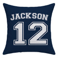 A square navy blue throw pillow featuring the name 'JACKSON' and number '12' printed in a white varsity-style font with navy outlines, shown against a plain white background.