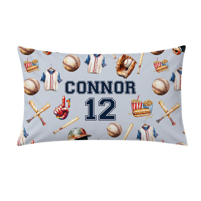A pillowcase featuring a baseball-themed pattern with the name 'CONNOR' and number '12' in navy blue, surrounded by baseball jerseys, balls, bats, and a glove.