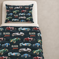 Custom racing-themed bedding set featuring a blanket and matching pillowcase with a dark navy background, printed with vintage race cars in red, blue, green, and silver, and personalized with the name 'Oliver James'.