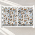 A white changing table with a personalized changing pad cover featuring a repeating pattern of teddy bears in strollers and carriages, blue stripes, and the name 'Oliver'.