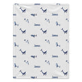 A personalized baby blanket with a white background, featuring a repeating pattern of blue whales and dolphins, along with the name 'James' printed in blue. The blanket is shown flat against a clean white background.