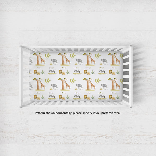 Wildwood Safari crib sheet personalized with Oliver in a white crib; caption notes horizontal pattern placement, with vertical available by request.