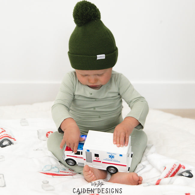 cute toddler playing with an ambulance toy on a personalized ambulance themed blanket