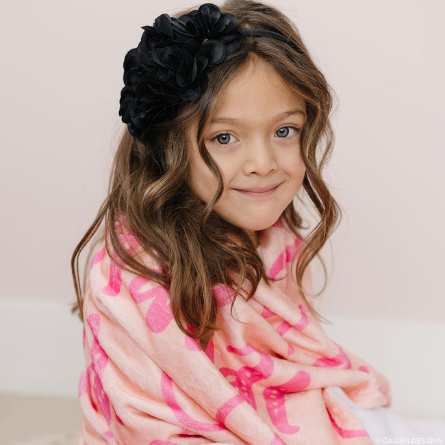 A little girl with a peach personalized blanket for kids