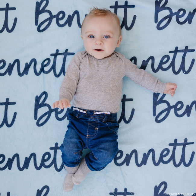 baby on blue personalized baby blanket with the name Bennett