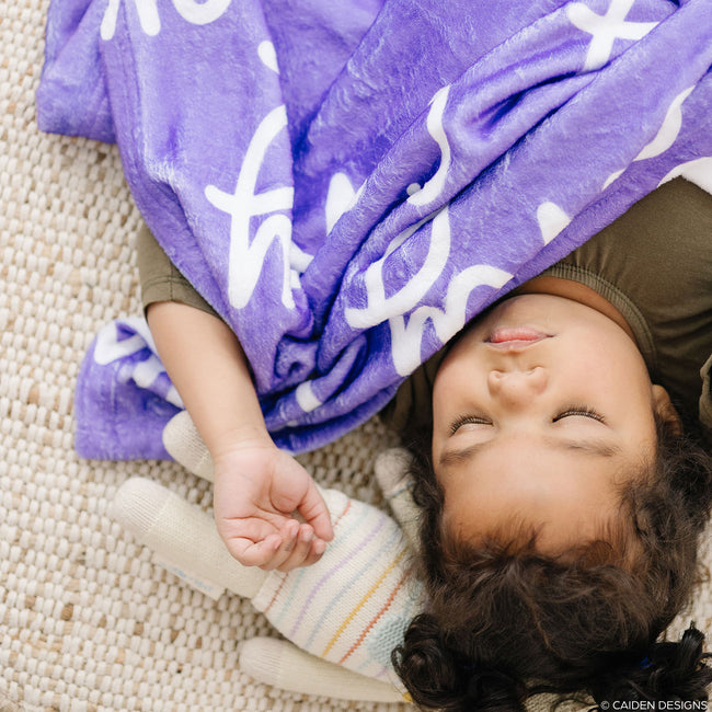 little girl sleeping with a purple personalized blanket
